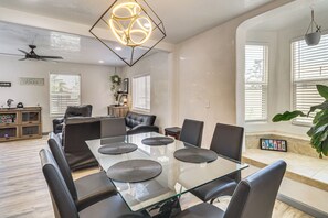 A modern dining area with a glass table, black chairs, and a unique geometric light fixture. - 2 Mi to Old Town ABQ! Remodeled Retreat w/ Yard (Albuquerque)