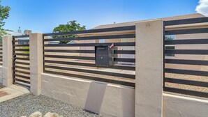 A gated entrance with a metal gate and a security keypad. - Room for 6 Cars on Balloon Fiesta Weekend (Albuquerque)