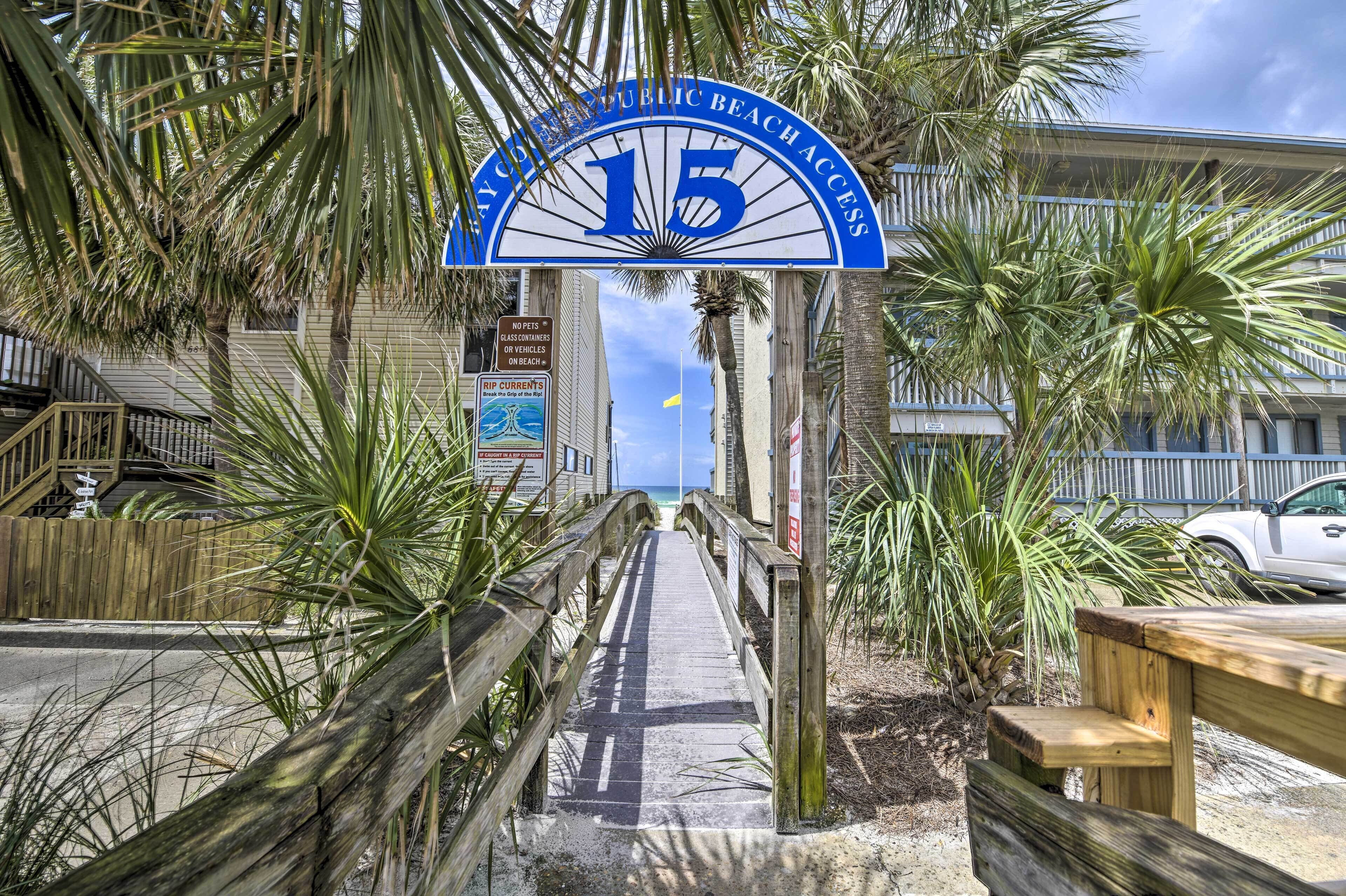 A wooden boardwalk leading to a beach entrance with a sign reading "15 Public Beach Access".