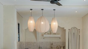 Eine moderne Küche mit einer zentralen Kochinsel, Pendelleuchten und einem Deckenventilator.