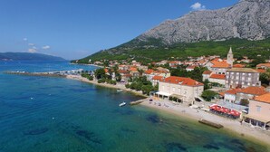 A coastal town with a prominent mountain in the background, clear blue waters, and a beach area with buildings and a pier. - Gorgeous apartment in Orebic with WiFi (Orebic)