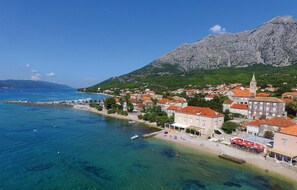 A coastal town with a prominent mountain in the background, clear blue waters, and a beach area with buildings and a pier. - Gorgeous apartment in Orebic with WiFi (Orebic)