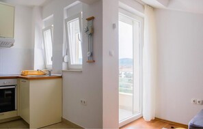 A kitchen with a built-in oven and a window with curtains. - Beautiful apartment in Sreser with WiFi (Sreser)