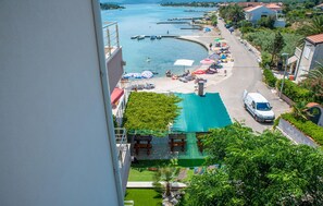 A coastal view with a swimming pool, beach umbrellas, and boats. - Beautiful apartment in Sreser with WiFi (Sreser)