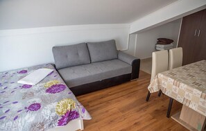 A compact room with a sofa bed, a dining table with chairs, and a small kitchenette area. - Beautiful apartment in Sreser with WiFi (Sreser)