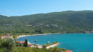 Eine Küstenstadt mit Strand, Booten und einer gebirgigen Kulisse.