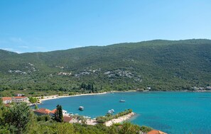 A coastal town with a beach, boats, and a mountainous backdrop. - Lovely apartment in Janjina with house sea view (Janjina)