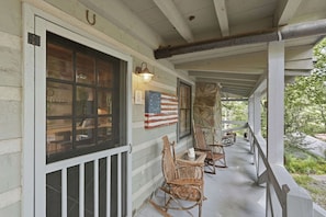 A porch with a railing, a table, and two rocking chairs. - Peace of Aska w/ Hot Tub (Blue Ridge)