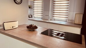 A modern kitchen with a Bosch toaster, a bowl of pine cones, and a window with blinds. - A large, charming vacation rental, formerly a wine cellar, located along the Canal du Midi. (marseillette)