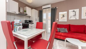 A modern living space with a dining area, red upholstered chairs, a red sofa, a white coffee table, and artwork on the walls. - Awesome apartment in Biograd na Moru with WiFi (Biograd na Moru)