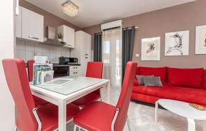 A modern living space with a dining area, red upholstered chairs, a red sofa, a white coffee table, and artwork on the walls. - Awesome apartment in Biograd na Moru with WiFi (Biograd na Moru)