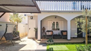 A courtyard with a seating area, a wooden deck, and a white balcony. - Awesome apartment in Biograd na Moru with WiFi (Biograd na Moru)