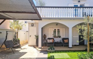 A courtyard with a seating area, a wooden deck, and a white balcony. - Beautiful apartment in Biograd na Moru with WiFi (Biograd na Moru)