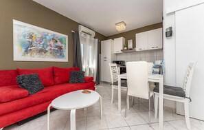 A modern living room with a red sofa, a white coffee table, and a painting on the wall. - Beautiful apartment in Biograd na Moru with WiFi (Biograd na Moru)