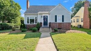 A two-story house with a front porch, a brick chimney, and a well-maintained lawn. - Classic 3 Bedroom Eastport Cottage with Large Yard and Free Parking (Annapolis)