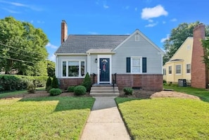A two-story house with a front porch, a brick chimney, and a well-maintained lawn. - Classic 3 Bedroom Eastport Cottage with Large Yard and Free Parking (Annapolis)