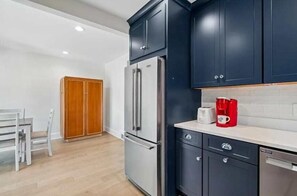 A modern kitchen with dark cabinets, a stainless steel refrigerator, and a white countertop. - Classic 3 Bedroom Eastport Cottage with Large Yard and Free Parking (Annapolis)