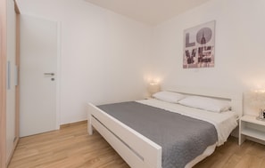 A bedroom with a bed, bedside tables, and a poster on the wall. - Stunning apartment in Turanj with WiFi (Turanj)