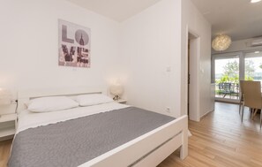 A modern bedroom with a bed, bedside lamps, a cityscape poster, and a view of the outdoors. - Stunning apartment in Turanj with WiFi (Turanj)