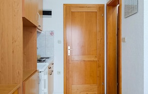 A kitchen with wooden cabinets, a stove, and a white countertop. - Amazing apartment in Vir with WiFi (Vir)
