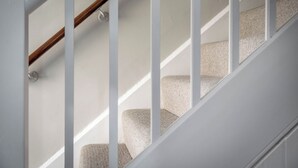 A staircase with white railings and carpeted steps. - East Lodge (Peterborough)