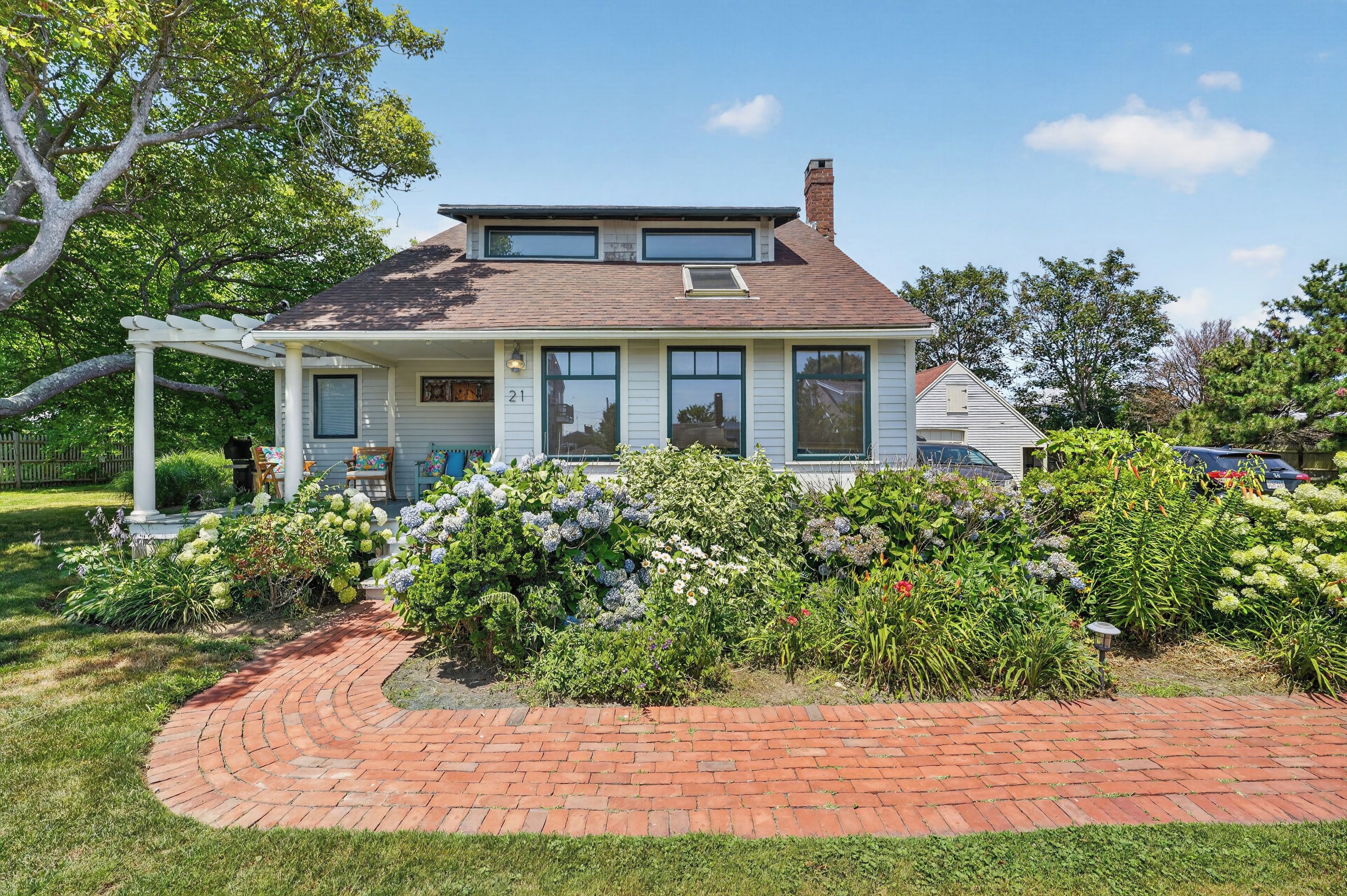 A two-story house with a brick pathway leading to the front door.