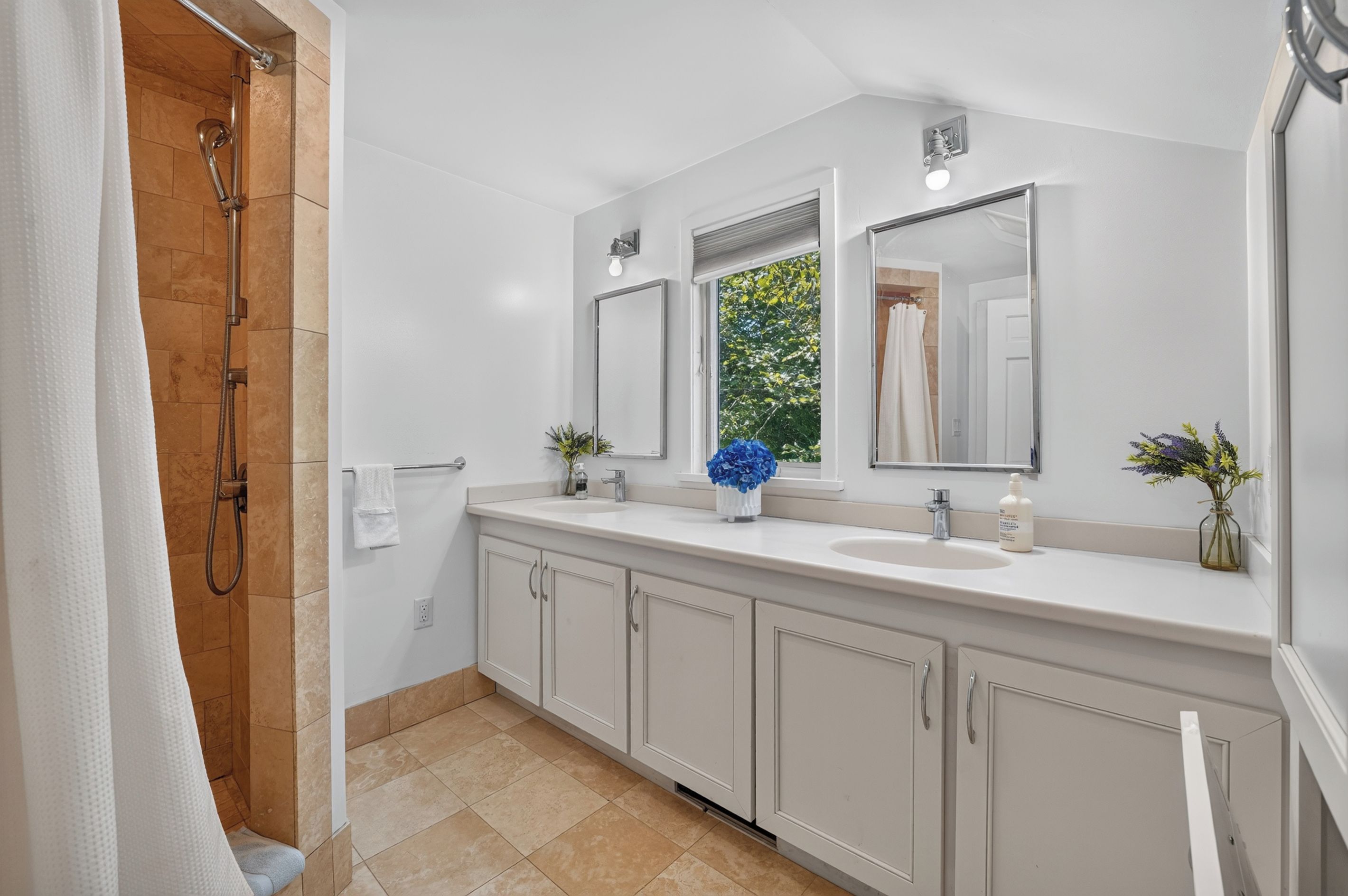 Un baño moderno con ducha, lavamanos y espejo.