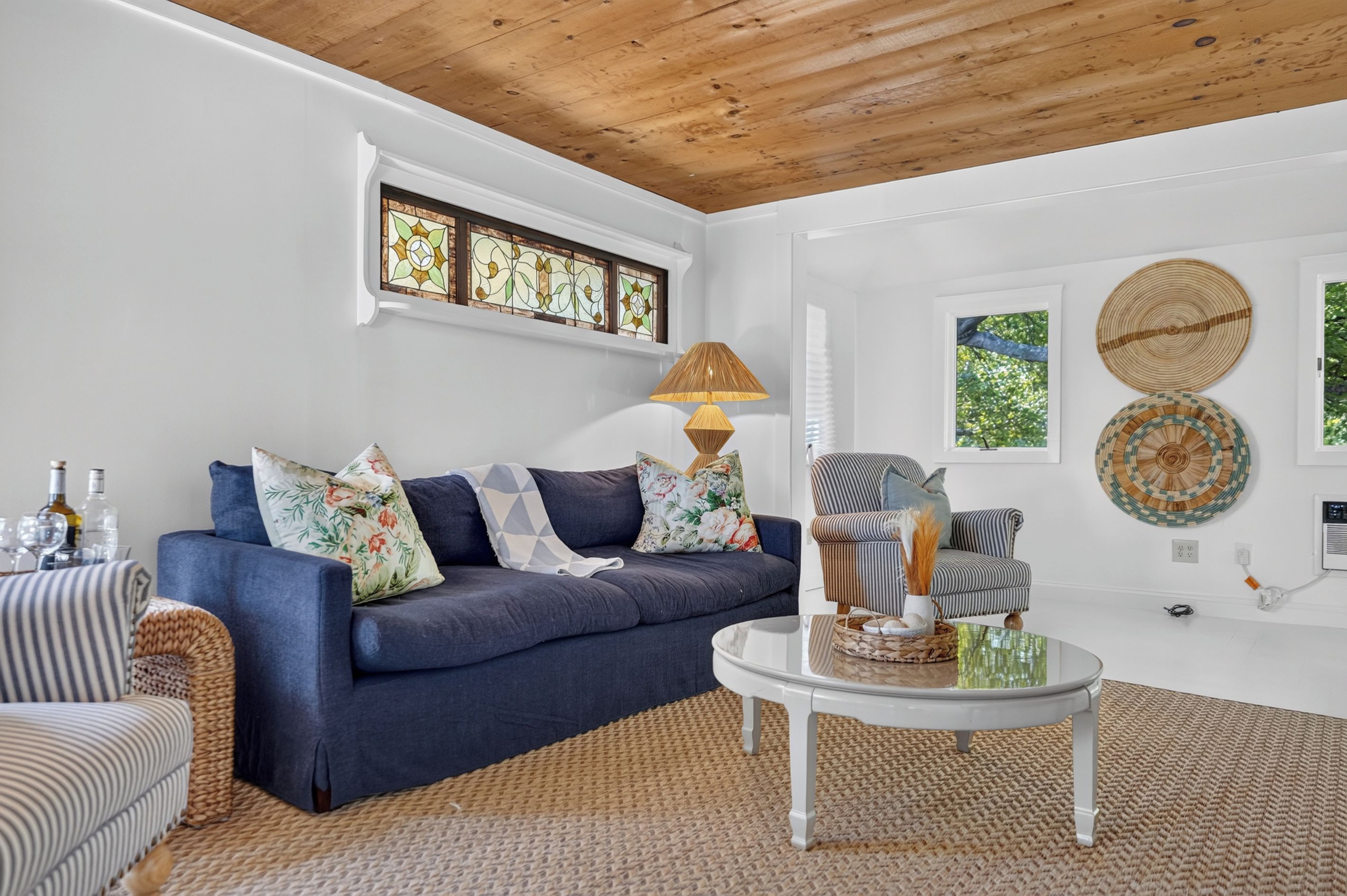 A living room with a blue sofa, a round coffee table, and a lamp.