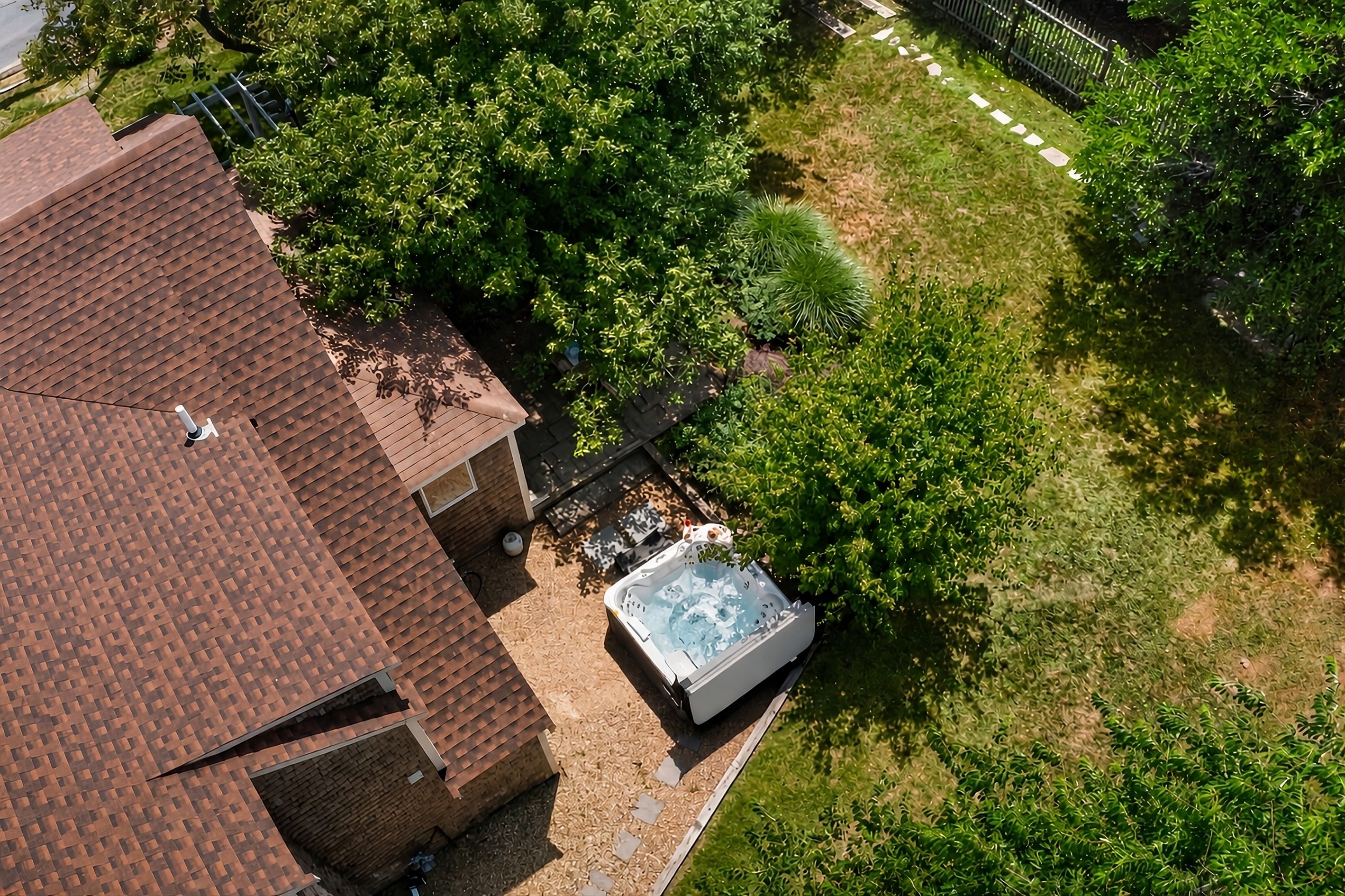 Aerial view of the private outdoor space and hot tub tucked beside the cottage.