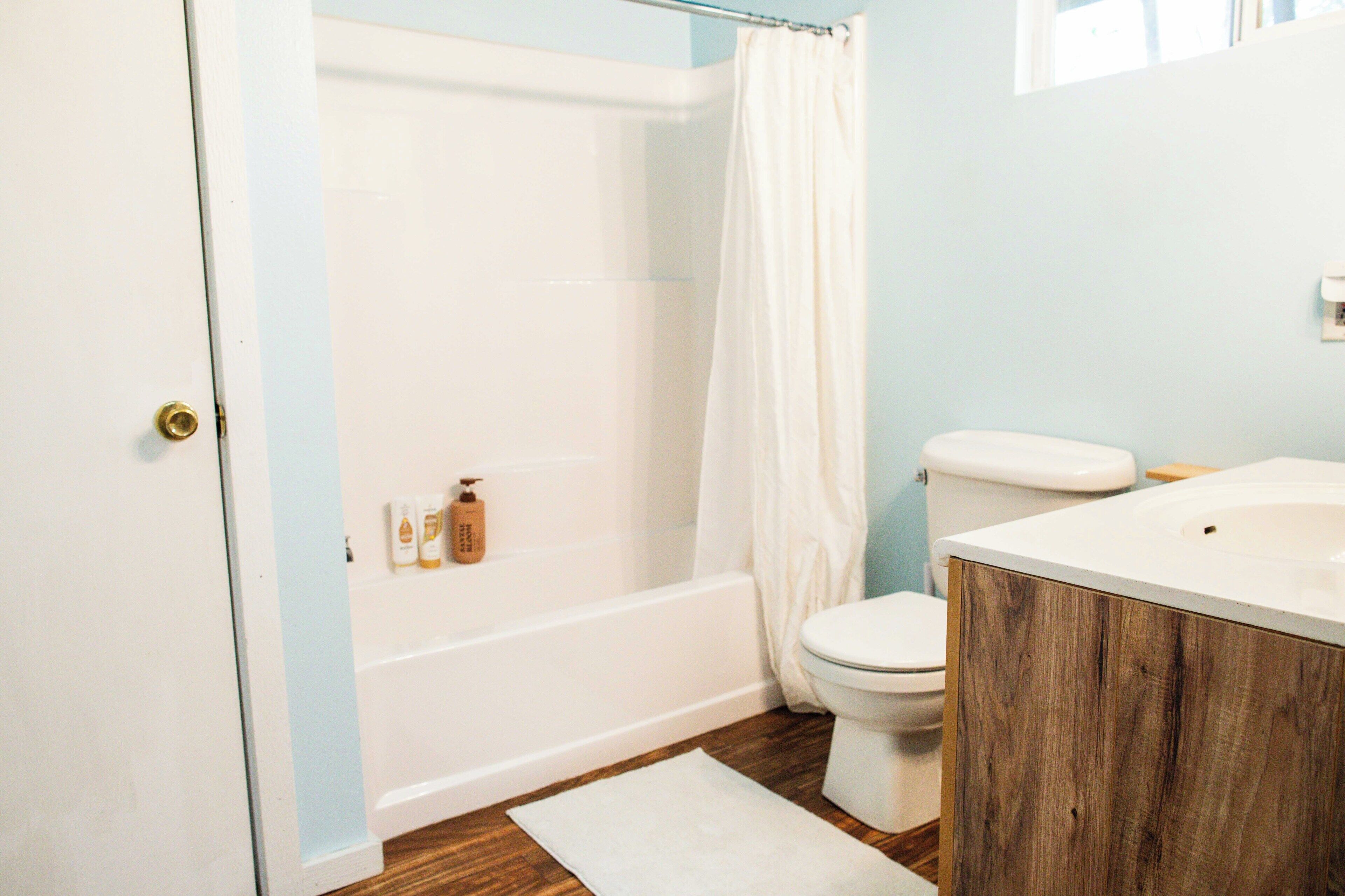 A bathroom with a bathtub, toilet, and vanity.