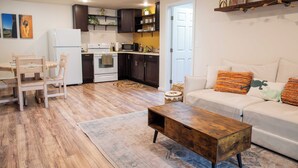 Uma sala de estar moderna com sofá, mesa de centro e área de jantar com cadeiras.