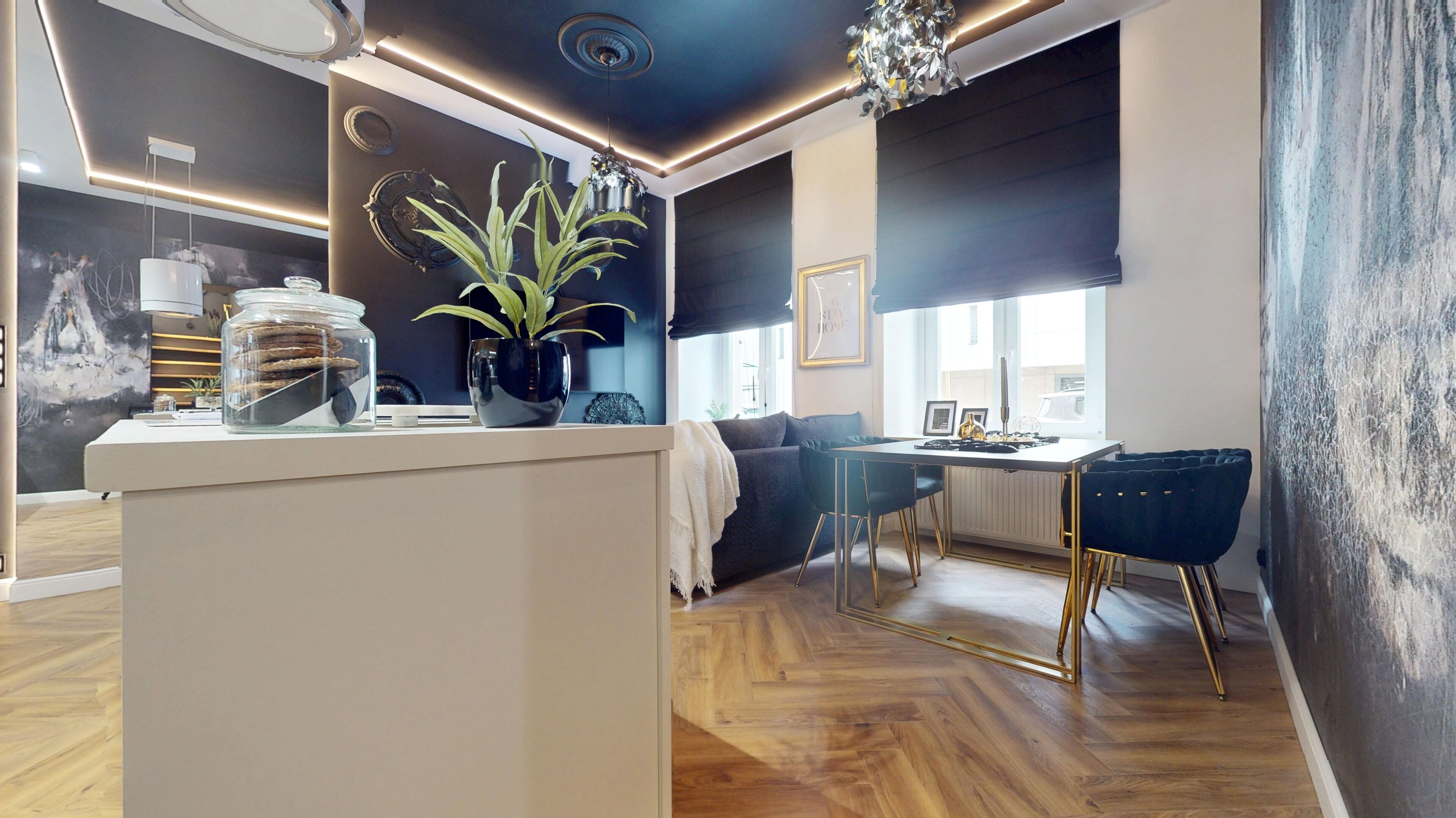 A modern living space with a central island, seating area, and a dining table.