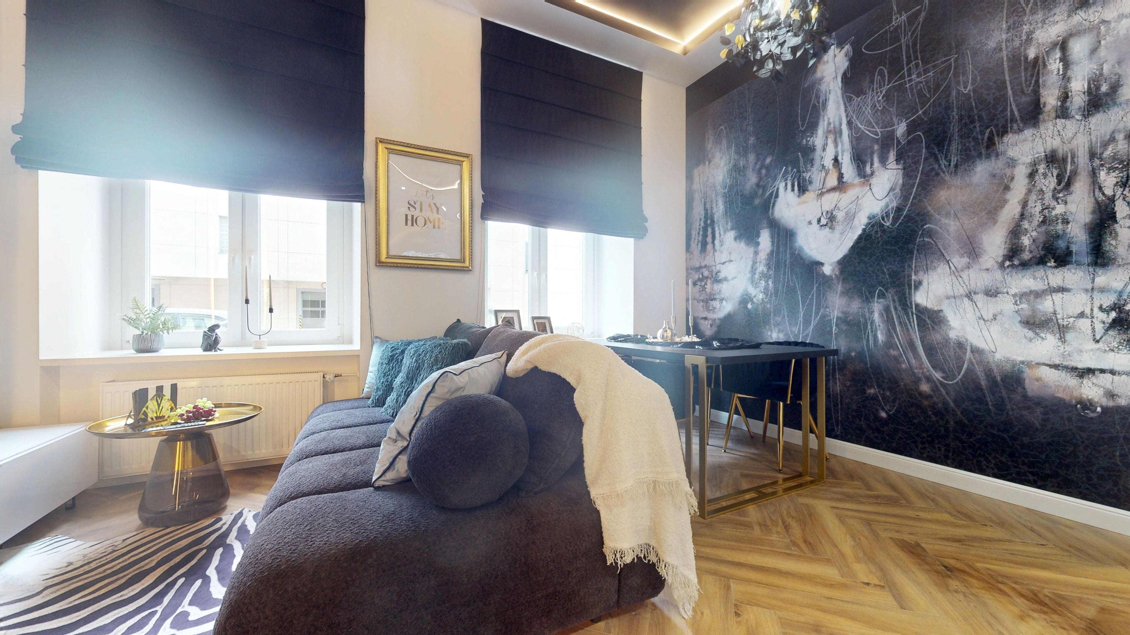 Un salon moderne avec un canapé, une table à manger et un grand tableau abstrait accroché au mur.