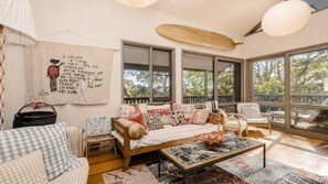 A cozy living room with a sofa, chairs, and a large window. - Coastal Wilderness Retreat (HARDYS BAY)