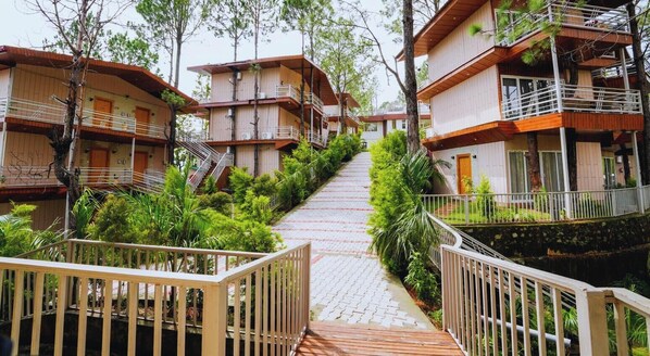 A multi-story wooden building with balconies and a central staircase. - Pacific Inn Prakrti the nature Lansdowne (Lansdowne)