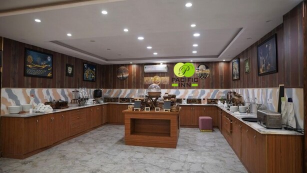A spacious kitchen with wooden cabinets, a marble countertop, and a central island. - Pacific Inn Prakrti the nature Lansdowne (Lansdowne)