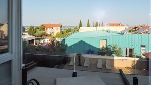 En balkong med utsikt över ett bostadsområde, inklusive hus och en vattenyta.