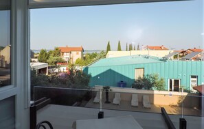 Ein Balkon mit Blick auf eine Wohngegend, mit Häusern und einem Gewässer.