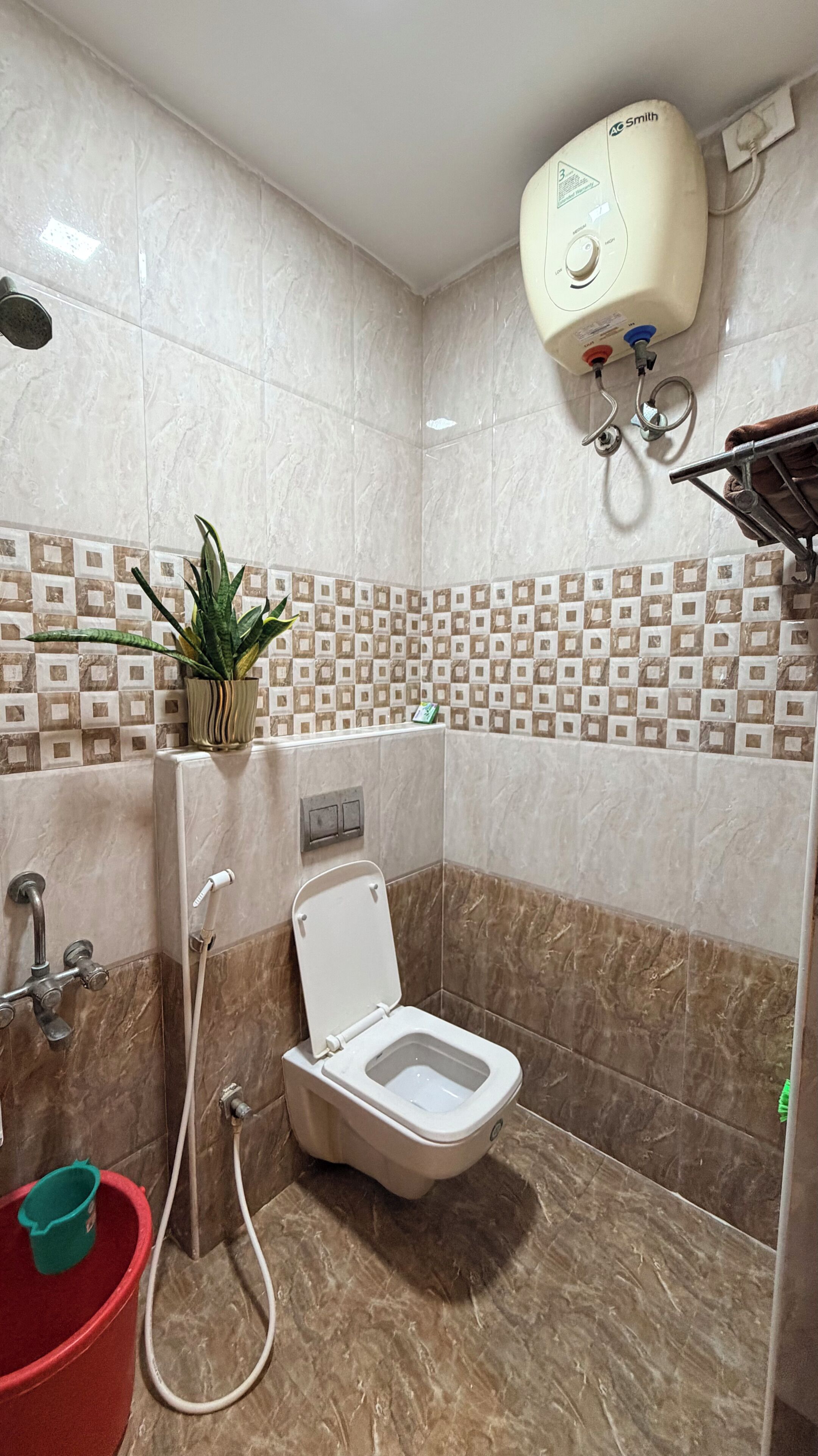 A bathroom with a toilet, shower, and a water heater.