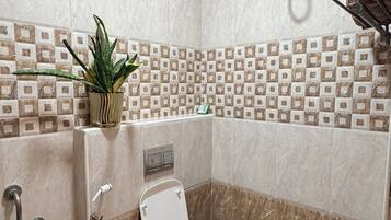 A bathroom with a toilet, shower, and a water heater.