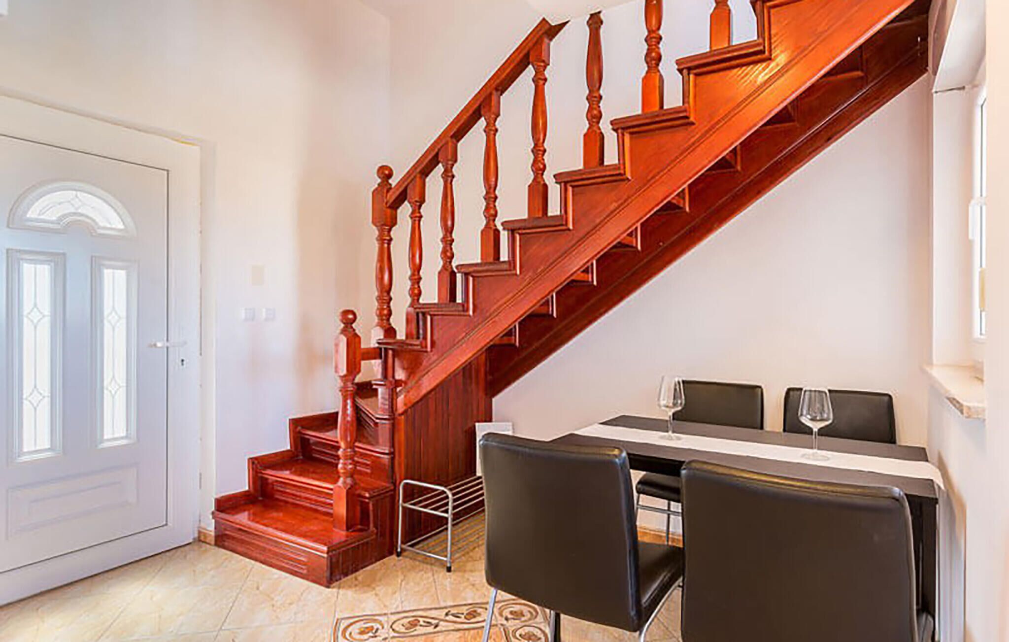 Un escalier menant à une salle à manger équipée d’une table et de chaises.