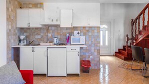 A compact kitchen with white cabinets, a microwave, a coffee maker, and a trash bin. - Apartment in Medulin (758) (Medulin)