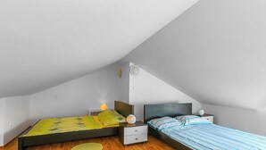 A bedroom with two beds, a nightstand, a bedside table, and a window. - Apartment in Medulin (760) (Medulin)