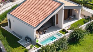 A modern two-story house with a swimming pool, a patio with outdoor furniture, and a well-maintained garden. - Stunning home in Zupanici with sauna (Zupanici)