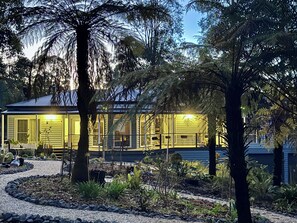 A house with a covered porch, surrounded by trees and a gravel path. - Private and cosy part of a house next to the forest. Close to main attractions. (Marysville)
