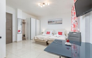 Ein modernes Hotelzimmer mit einem Bett, Nachttischen, einem Flachbildfernseher und einem Esstisch.