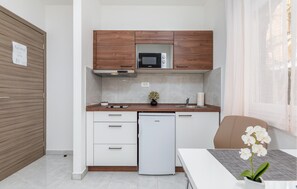 A compact kitchen with a microwave, a small refrigerator, and a sink. - Nice apartment in Pula with WiFi (Pula)