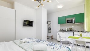 A modern hotel room with a bed, a TV, a kitchenette, and a bathroom. - Pet friendly apartment in Pula with WiFi (Pula)