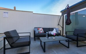 An outdoor seating area with a sofa, two armchairs, and a coffee table. - Awesome apartment in Galizana with WiFi (Galizana)