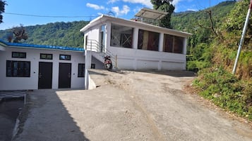 A building with a covered entrance and a motorcycle parked in front.